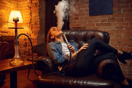 青春女子在hockah酒吧抽烟寒冷Shisha吸烟传统bong文化烟草香味以放松用hooka休息背景图片