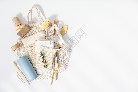 网格袋装有棉花袋清洁工具可重复使用的瓶子竹餐具和牙刷的免费塑料套装零废物生态友好概念平铺背景