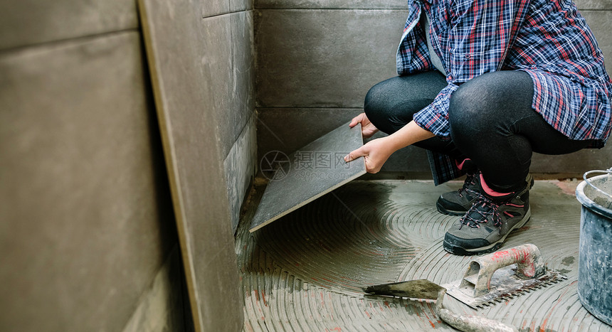 无法辨认的女建筑工在露台铺设新的瓷地板女建筑工在露台铺设新的瓷地板图片