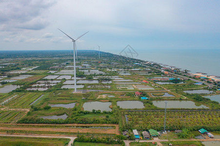 泰国NakhonSiThammarat市风力涡轮机与拥有海空线的住宅建筑空中观测亚洲城市建筑景观背背景图片