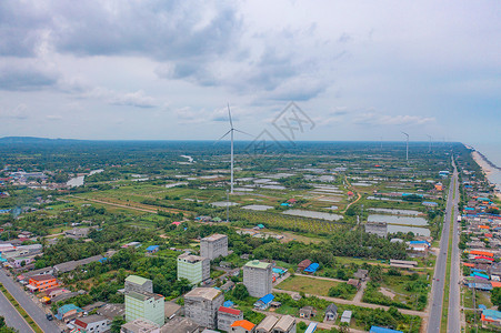 泰国NakhonSiThammarat市风力涡轮机与拥有海空线的住宅建筑空中观测亚洲城市建筑景观背背景图片