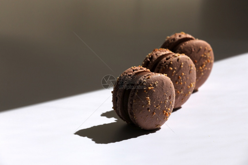 甜棕色巧克力法国马卡龙或甜点在白色背景中孤立窗外有光线复制空间甜褐色巧克力法国马卡龙或甜点白背景中孤立窗外有光线复制空间图片