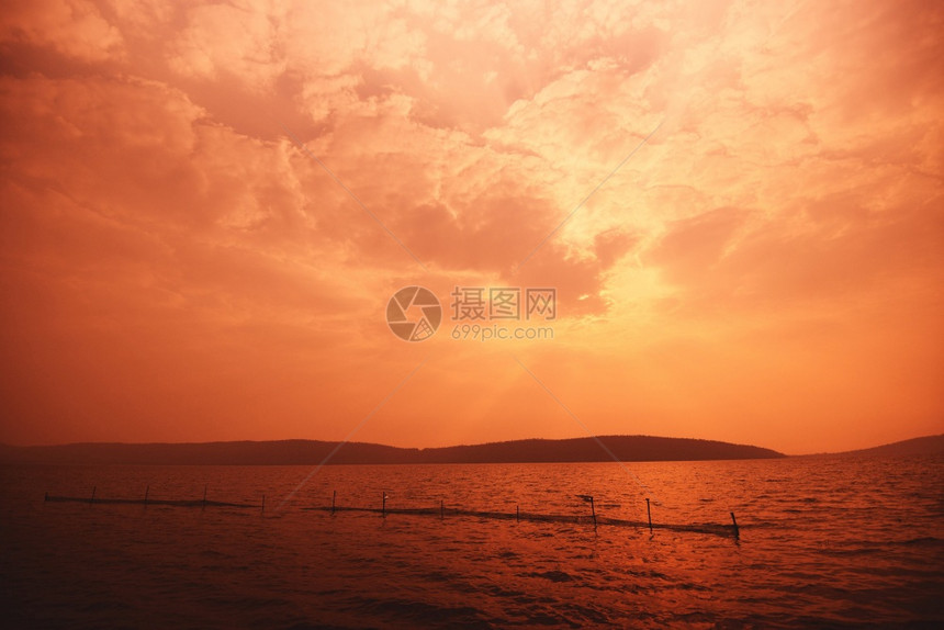 海洋有山地岛屿背景的海有红云滩热带日落图片