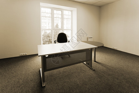 现代办公室一扇窗口的椅子和桌图片