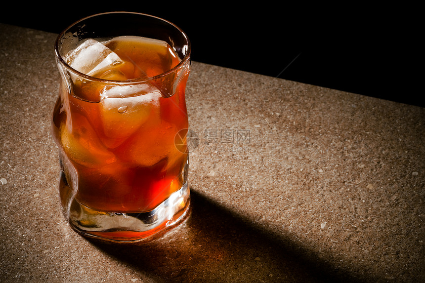 从木制桌上威士忌的玻璃杯图片