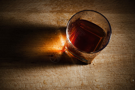 酒精上瘾在木制的桌上用玻璃制成的背景
