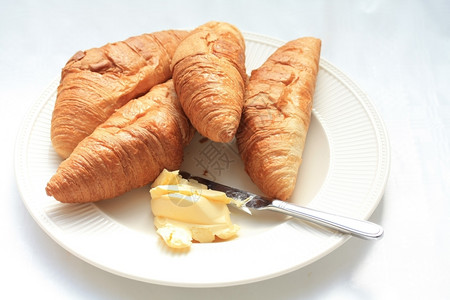 典型的法国早餐羊角面包和黄油图片