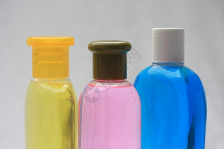 三瓶黄色粉红和蓝洗发水背景图片