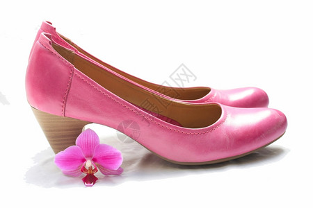 一双粉色皮革女士鞋和粉红兰花图片