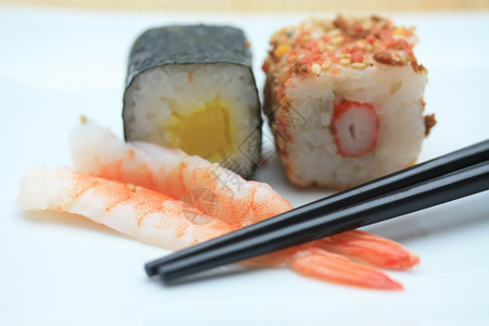 两片寿司芝麻和大米以及一种传统马基寿司由海藻滚的稻米制成称为Nori图片