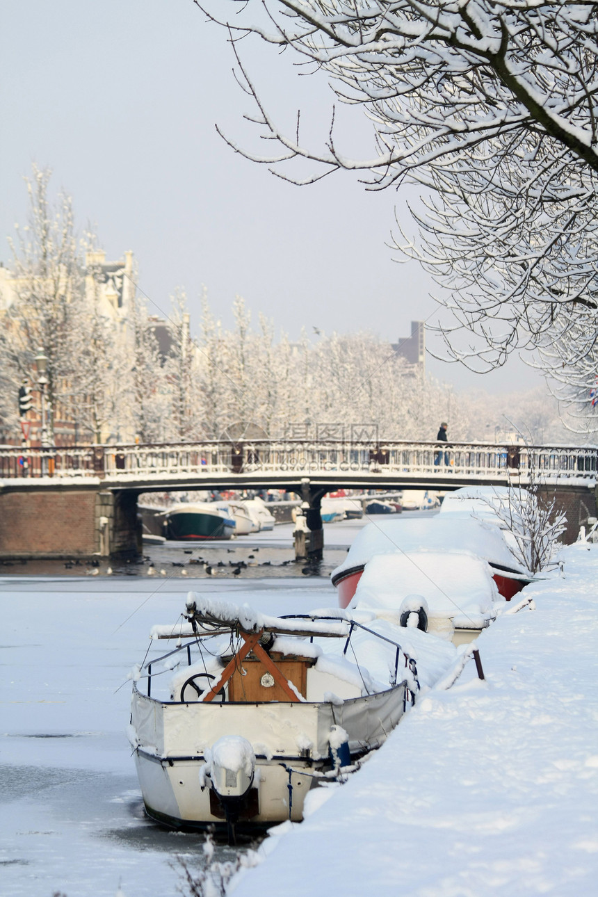 荷兰Haarlem的一条冰冻运河有雪盖船图片