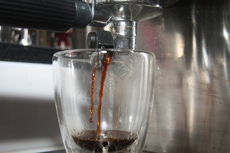 在传统的意大利咖啡制机下紧闭的玻璃杯图片