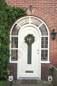 古老的白色前门与圣诞节花圈高清图片