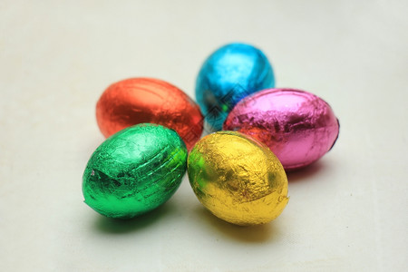以各种颜色的金属叶状粉巧克力圆形鸡蛋背景图片
