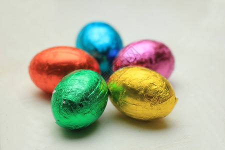 以各种颜色的金属叶状粉巧克力圆形鸡蛋背景图片
