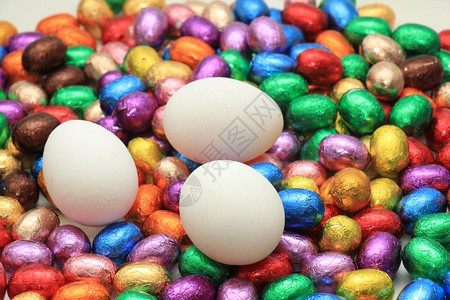 鸡蛋在一堆多彩的包着巧克力蛋上背景图片