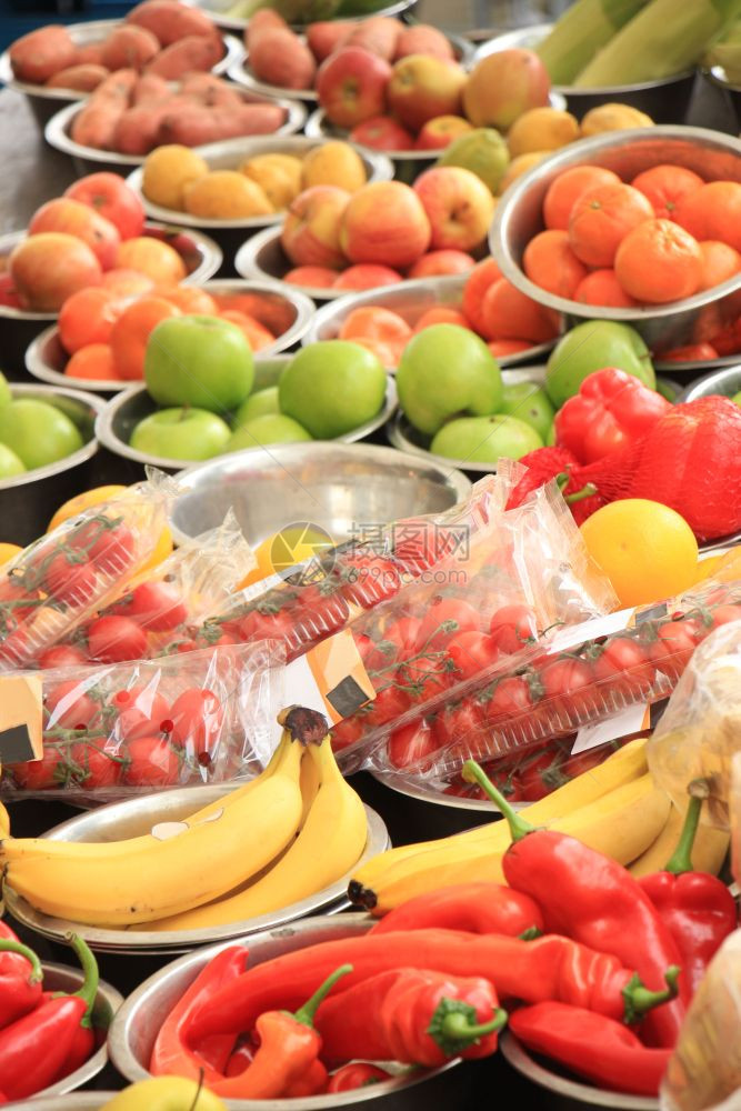 市场上的新鲜水果和蔬菜苹香蕉胡椒和小金属碗中的其他蔬菜图片