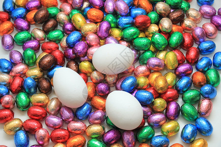 鸡蛋在一堆多彩的包着巧克力蛋上背景图片