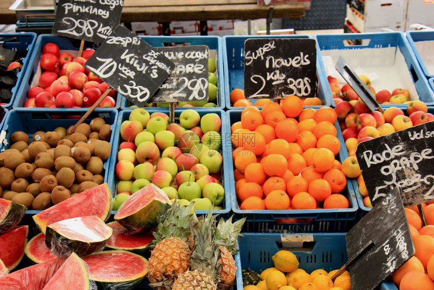 市场摊位上的新鲜水果关于标签的文字荷兰语各种水果的名称和价格橙兰果苹最好的kiwi水果图片