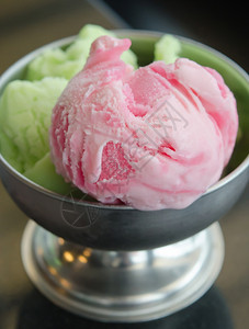 关闭草莓冰淇淋和绿色茶叶冰淇淋在碗中甜的图片