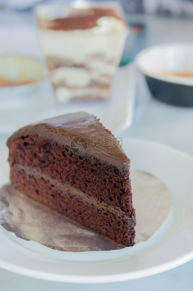 把一片巧克力软糖蛋糕放在白色盘子上巧克力蛋糕图片