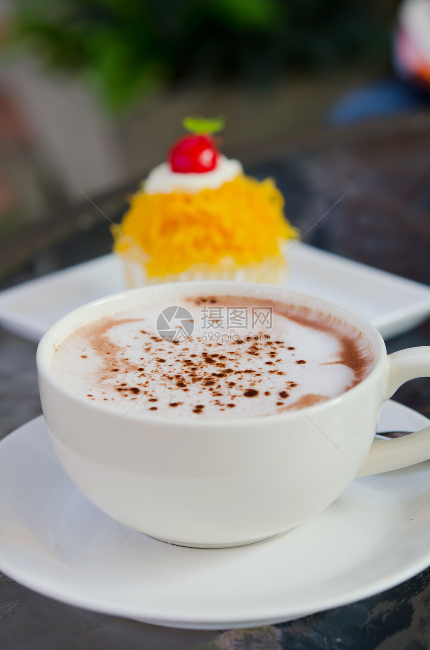 加热卡布奇诺白咖啡杯和甜蛋糕图片