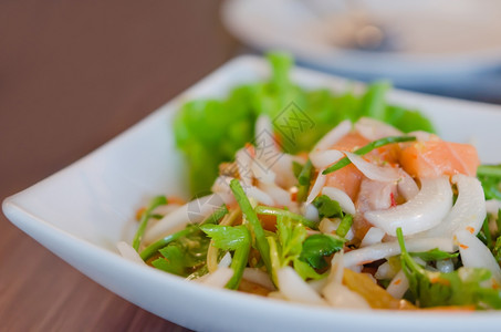 香辣鲑鱼沙拉配有混合蔬菜和草药图片