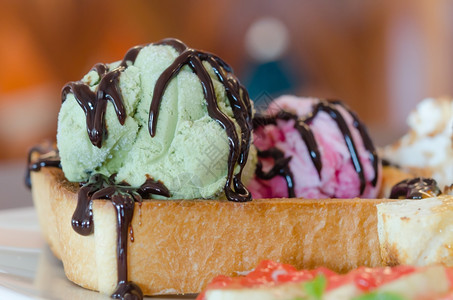 关闭绿色冰淇淋加蜂蜜吐司和奶油加巧克力酱汁蜂蜜吐司和冰淇淋图片