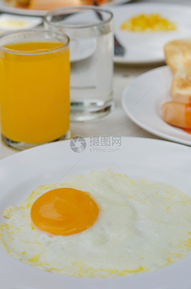 炸鸡蛋和果汁把炸鸡蛋放在白盘上早餐吃橙汁图片