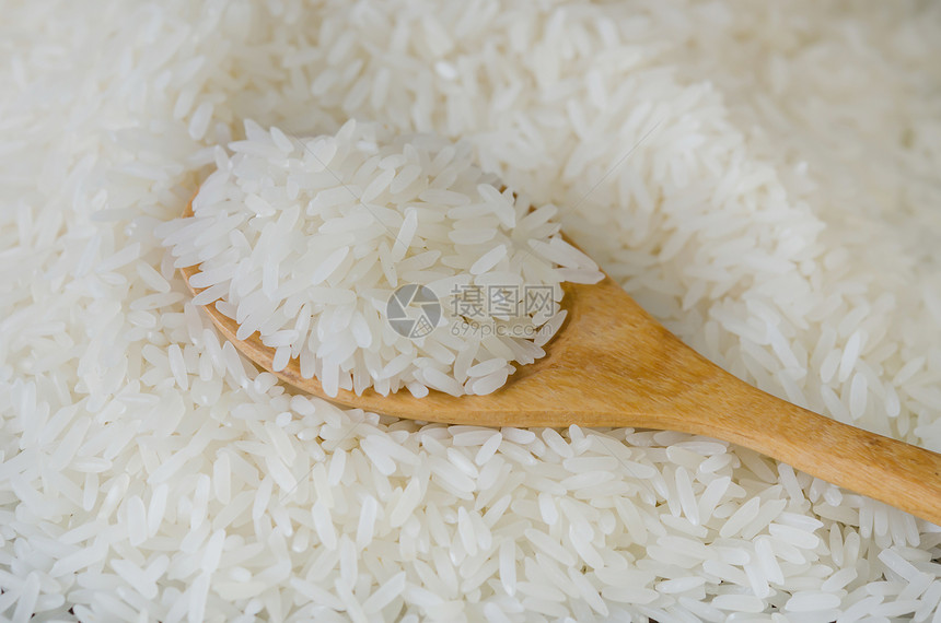木勺子和米饭放在背景上图片