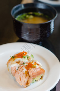 烤鲑鱼卷寿司上面顶着虾蛋白菜上边配有大米汤鲑鱼卷寿司图片