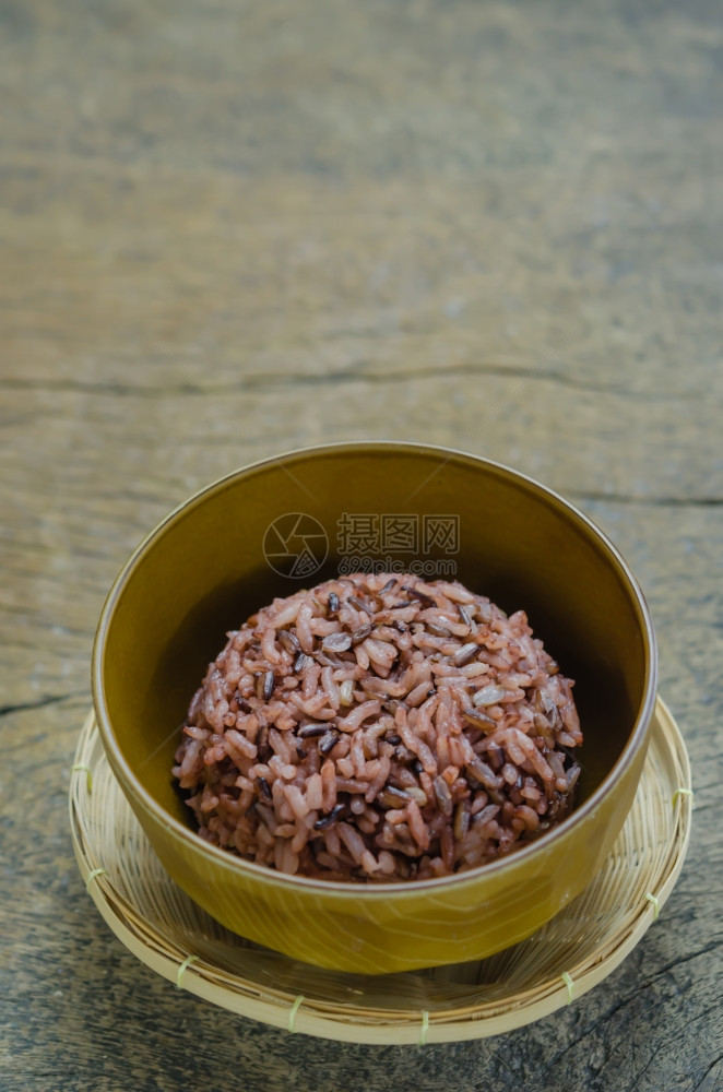 红莓大米在木制桌上的棕碗中图片