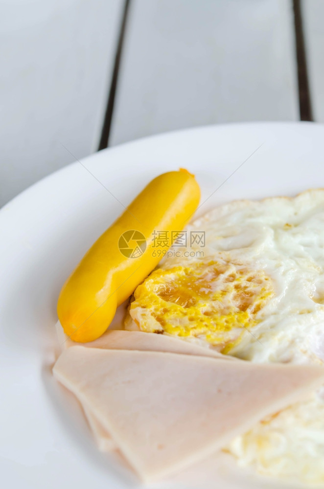 新鲜早餐炒蛋火腿和白菜上的香肠图片