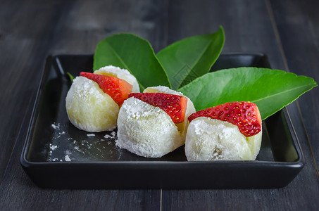 草莓大福摩奇日本甜点草莓大福摩奇日本甜点黑碟木背景图片
