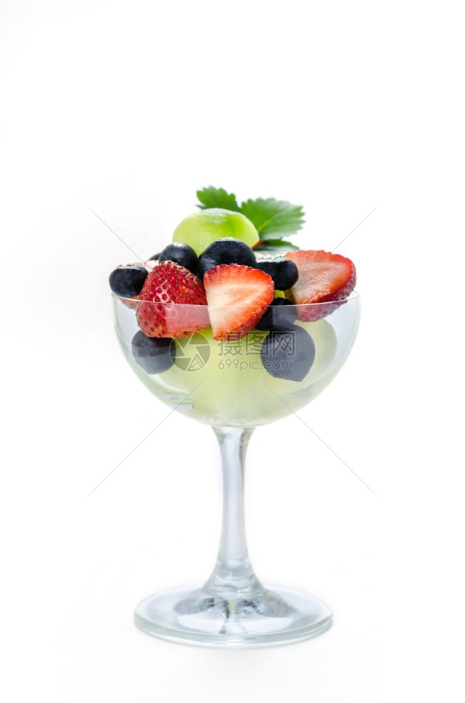 新鲜的森林浆果和甜瓜在白色背景的玻璃杯中图片