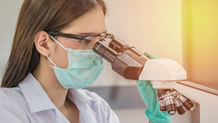 在实验室工作的科学家在实验室通过显微镜观察的科学家图片