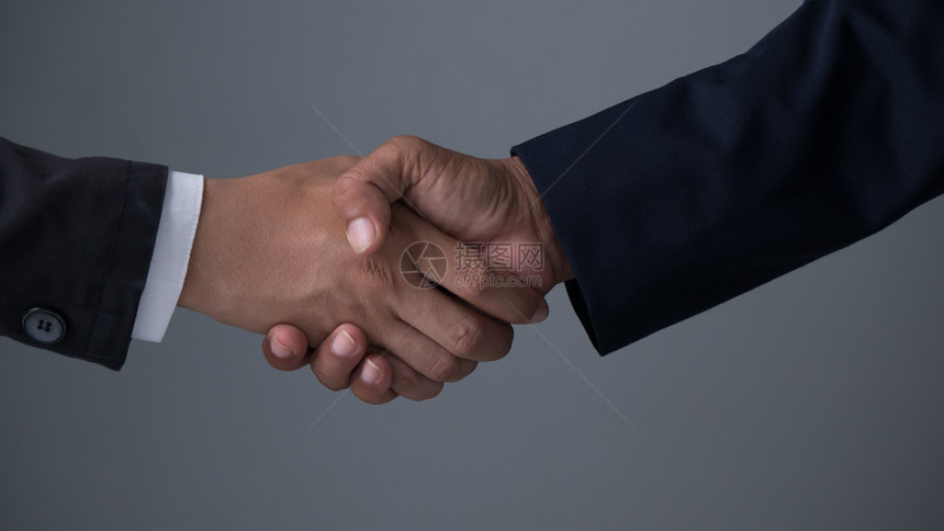 与商业伙伴握手图像商人握手在灰色背景上握着手图片
