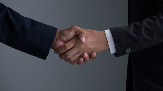 与商业伙伴握手图像商人握手在灰色背景上握着手背景图片