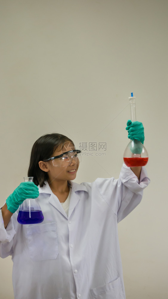 亚洲小女孩持有测试管亚洲小女孩持有测试管或实验室酒瓶教育概念图片