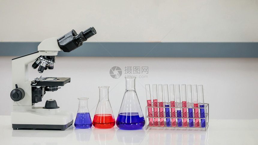 实验室研究含有带显微镜的化学液体气瓶图片