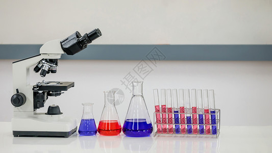 实验室研究含有带显微镜的化学液体气瓶图片