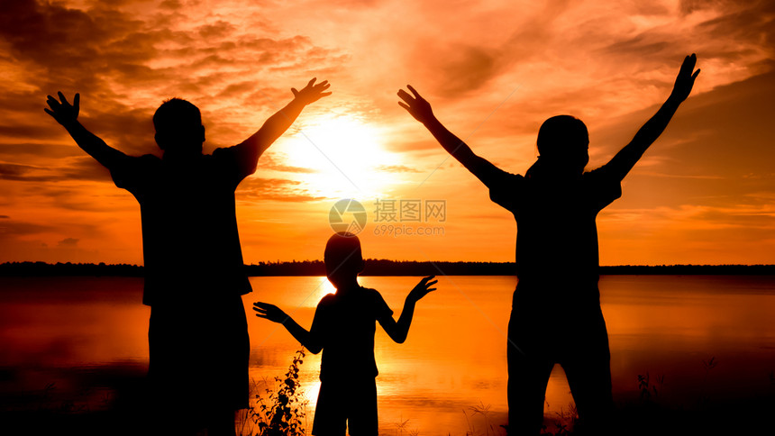 幸福的家庭在黎明时站立自然的日落图片