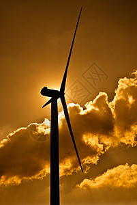 太阳后光的风力涡轮机黄天空和云彩图片