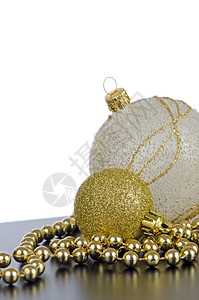 金色圣诞球黑表面和白背景上都有装饰品图片