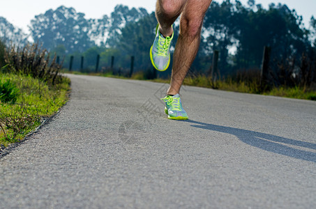运动男鞋素材在乡间公路上运动鞋在户外男鞋在年轻人的训练中运动模糊重心放在后跑鞋上背景