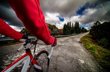骑着自行车的穿过山上的沥青路蓝天和云层图片