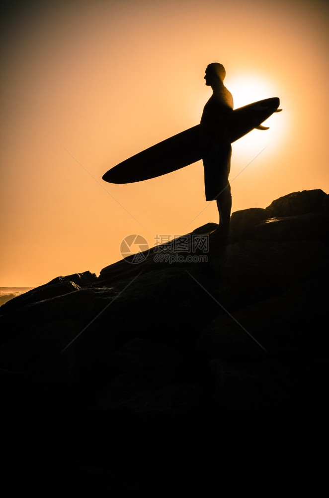 一个在葡萄牙日落时看海浪的冲者图片