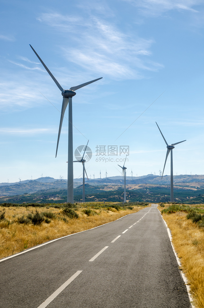 穿越风力涡轮机山地的平面公路图片