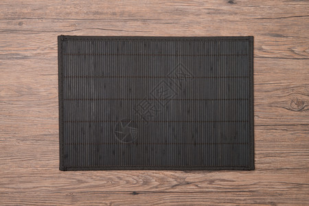 木制甲板桌上的竹子垫背景图片