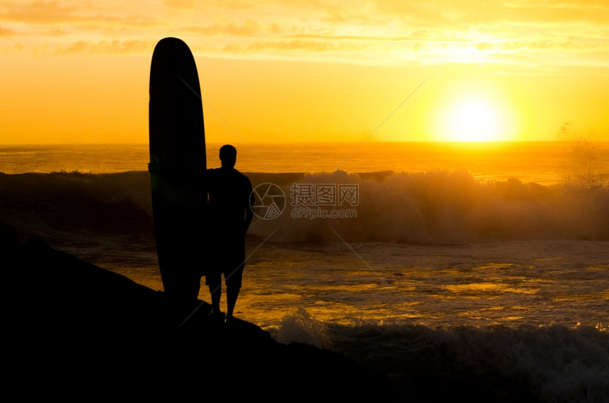 一个长的登机者观看葡萄牙日落时的海浪图片